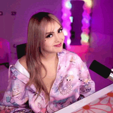 a woman sitting in front of a microphone wearing a pink shirt that says ' unicorn ' on it