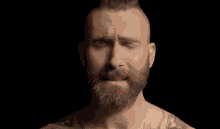 a man with a beard is crying with his eyes closed .