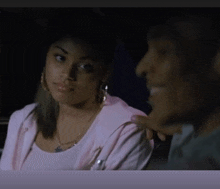 a woman in a pink jacket looks at a man