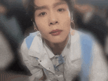 a close up of a person wearing earrings and a white shirt