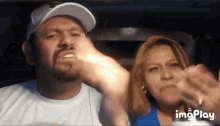 a man and a woman are sitting in a car and their faces are shown in a gif that says imgplay