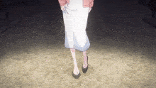 a woman in a white skirt and black shoes is walking