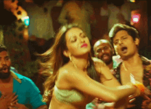 a woman in a striped top is dancing in front of a crowd of people