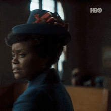 a close up of a woman wearing a hat and a hbo logo