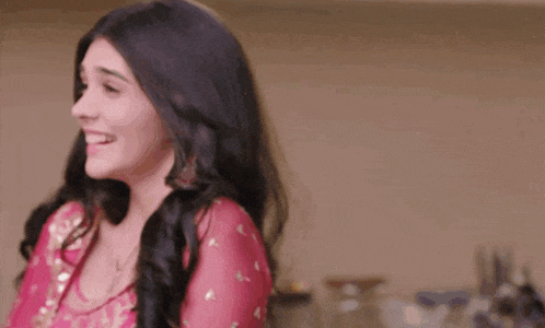 a woman in a pink dress is laughing and smiling .