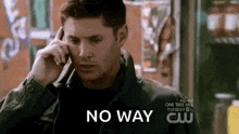 a man is talking on a cell phone with the words `` no way '' behind him .