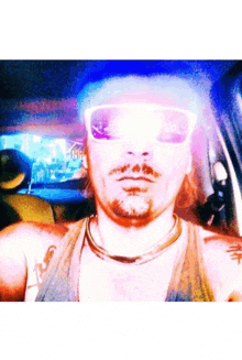 a man wearing sunglasses and a hat is taking a selfie in a car