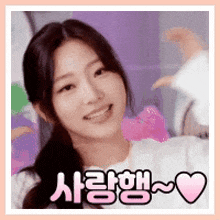 a close up of a woman making a heart shape with her hands and smiling .