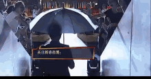 a man in a suit is holding an umbrella in front of a crowd of people