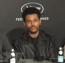 a man sitting at a table with bottles of pellegrino water