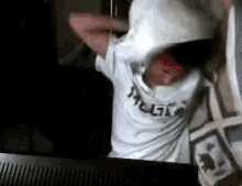 a person is holding a pillow over their head in front of a tv .