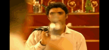 a man in a white shirt is holding a bottle of jack daniel 's whiskey .