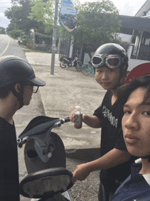 a boy wearing a black shirt that says ' eclectic ' on it is holding a can of soda