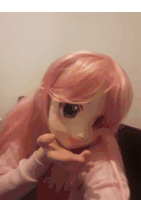 a close up of a doll with pink hair and a white shirt