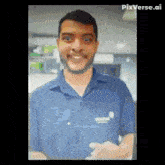 a man with a beard wearing a blue shirt is smiling and looking at the camera .