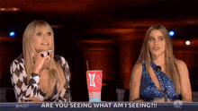 two women are sitting next to each other and one of them is holding a sonic cup