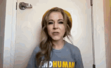 a woman wearing a hat and a t-shirt with the word human on it .