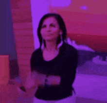 a woman is smiling in front of a purple background .