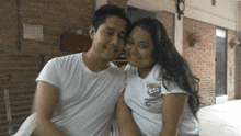a man and a woman are posing for a picture and the woman is wearing a white shirt with a monkey on it