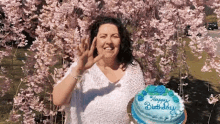 a woman holds a cake that says happy birthday on it