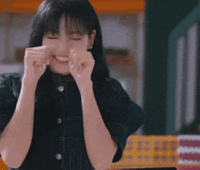 a woman with a surprised look on her face is sitting at a table with her hands in the air ..