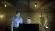 a man wearing glasses is looking at a computer screen