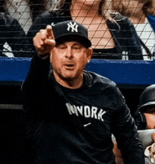 a man wearing a ny hat and a nyyork shirt is pointing
