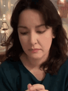 a close up of a woman 's face with a lamp behind her