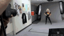 a person taking a picture of a woman in a room with a wwe logo