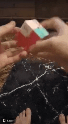 a person is holding a cube with a bow on it in their hands .