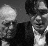 a black and white photo of two men in suits and ties