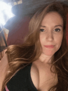 a woman with long hair is taking a picture of herself