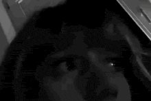 a close up of a person 's face in a black and white photo looking up at the camera .