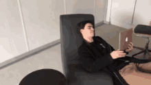 a man is laying in a chair with a laptop on his lap .