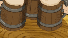 three wooden mugs filled with beer are sitting on a wooden table