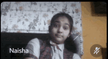 a girl named naisha is sitting in front of a floral wall