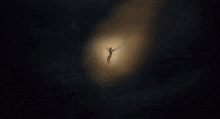 a silhouette of a person floating in the air with their arms outstretched