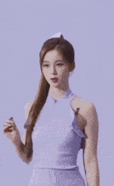 a woman in a purple tank top is holding a purple balloon .