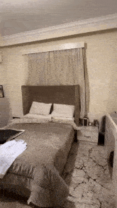 a bedroom with a bed , two nightstands , a window and a marble floor .