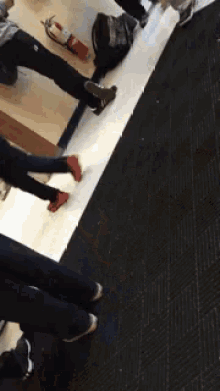 a group of people are standing on a carpeted floor in a room .