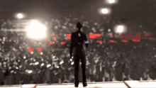 a blurry picture of a man standing on a stage in front of a crowd