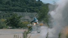 a person riding a motorcycle on a dirt road with smoke coming out of it