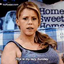 a woman is sitting on a couch and saying `` this is my lazy sunday . ''