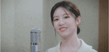 a young woman is smiling in front of a microphone