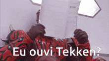 a man in a red costume holds a piece of paper over his face and says eu ouvi tekken