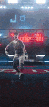a man in a baseball uniform is jumping in the air in front of a scoreboard with the letter j on it