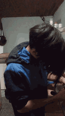 a man in a blue jacket is brushing his hair with a brush