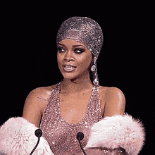 a woman in a pink dress is standing in front of a microphone .