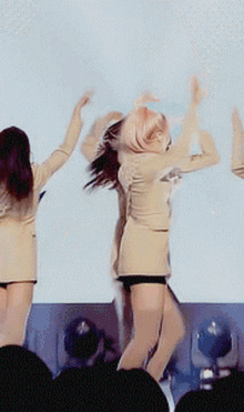 a group of women are dancing on stage in front of a crowd