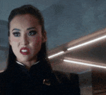 a close up of a woman 's face with red lips and a serious look on her face .